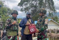 ‎Personel Satgas Yonif 521/DY  menyusuri jalan kampung dan mendatangi warga langsung untuk memastikan bantuan totebag sembako tepat sasaran.