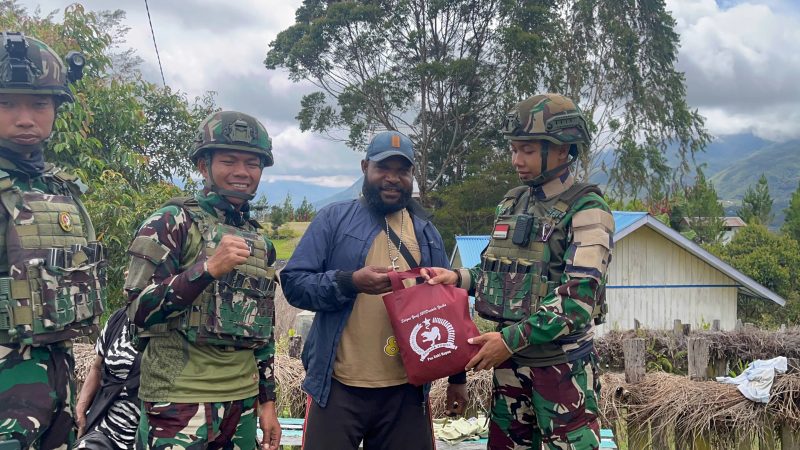 ‎Personel Satgas Yonif 521/DY  menyusuri jalan kampung dan mendatangi warga langsung untuk memastikan bantuan totebag sembako tepat sasaran.