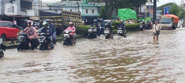 Warga mendorong sepeda motor yang mogok saat melewati banjir rob di Jalan Tanjungpura, Pontianak, Kalbar, Senin (8/12/2025).